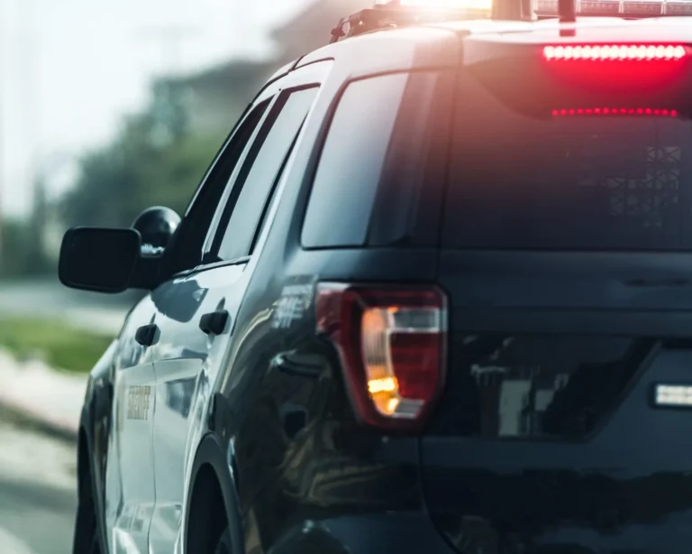 vehículo policial con las luces rojas encendidas