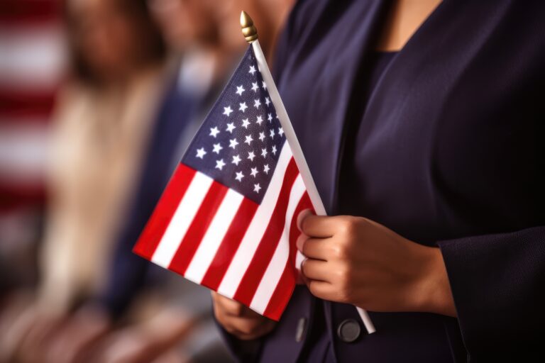 Person holding a small American flag during a U.S. citizenship ceremony, symbolizing the 2025 citizenship test changes.