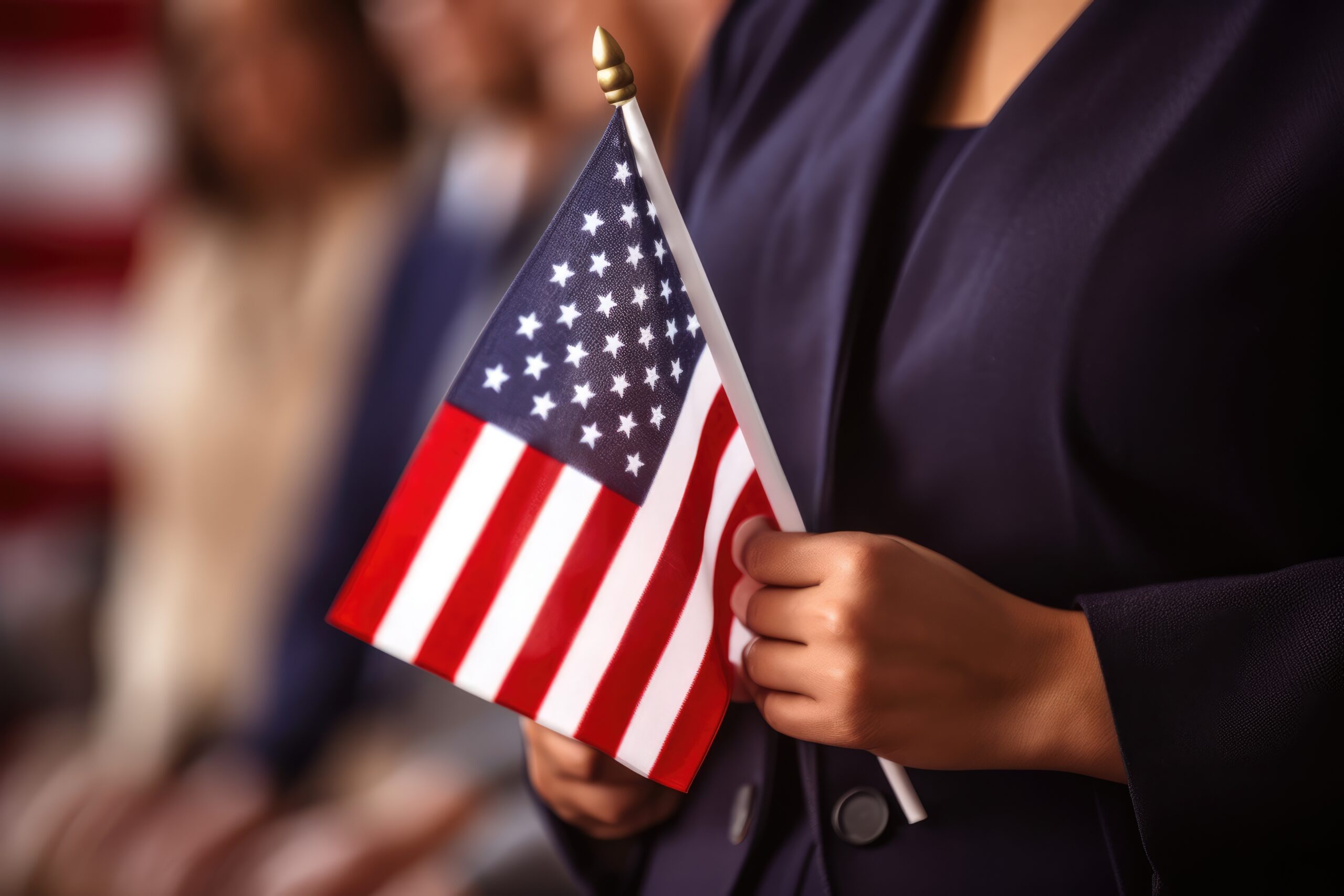 Female immigrant holding a small US flag the day of her naturalization Person holding a small American flag during a U.S. citizenship ceremony, symbolizing the 2025 citizenship test changes.