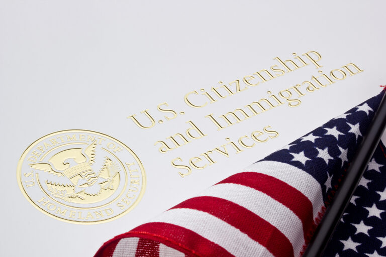 Fotografía del membrete del USCIS con una bandera estadounidense superpuesta.