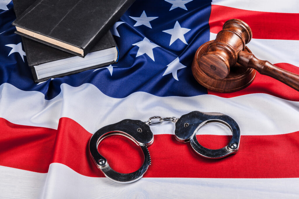 gavel handcuffs and american flag on wooden background