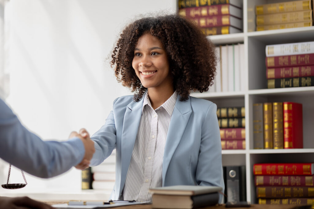 a sibling attorney at rozas immigration law firm shaking the hand of her client