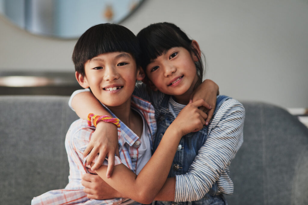 2 siblings hugging excitedly as their child visas were just approved with help from child visa attorneys at rozas law firm