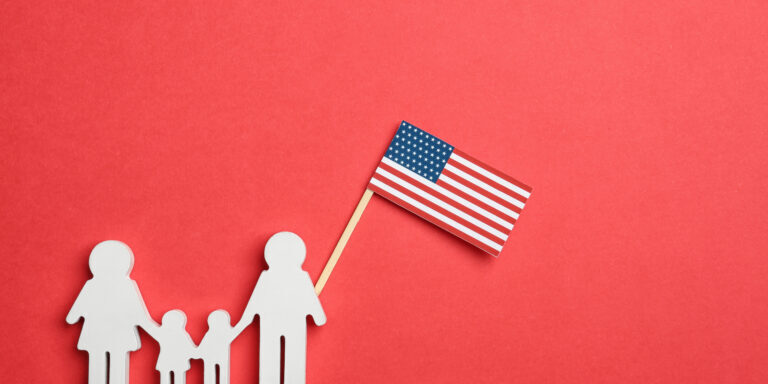 a cutout of a family of 4 next to an american flag for visa changes in 2026