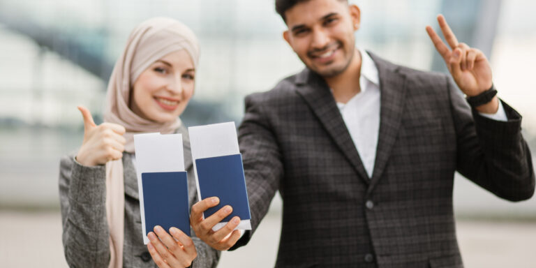 Una joven pareja musulmana sostiene sus pasaportes, lo que significa que acaban de obtener la doble nacionalidad con la ayuda del bufete de abogados Rozas Immigration.