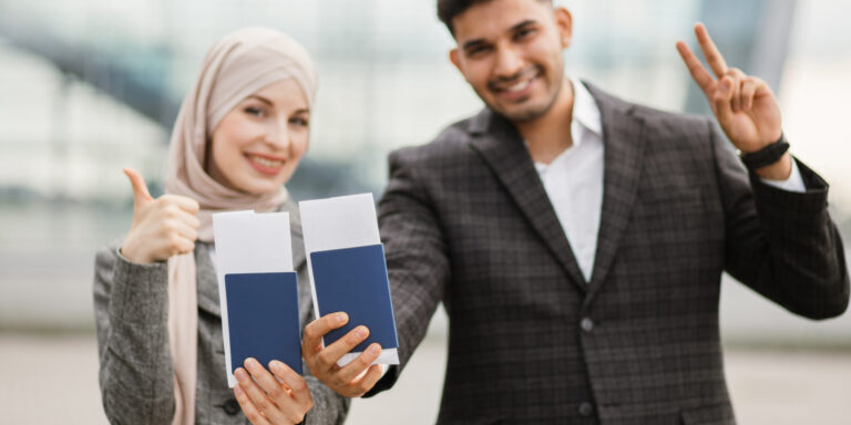 Una joven pareja musulmana sostiene sus pasaportes, lo que significa que acaban de obtener la doble nacionalidad con la ayuda del bufete de abogados Rozas Immigration.